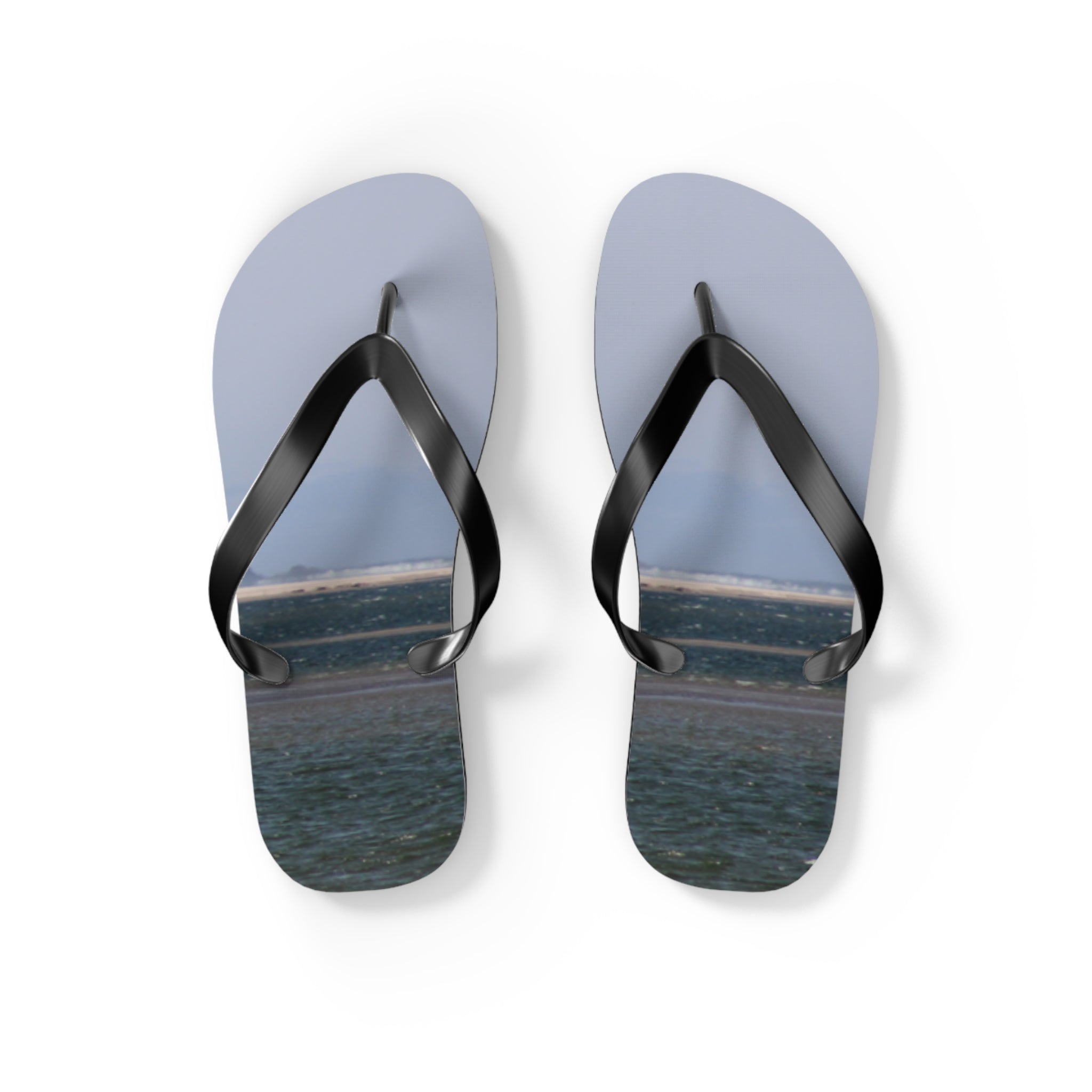 Light grey flip-flops with a beach scene graphic on white background.