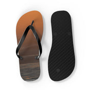 Orange sunset sky on flip-flop with black sole and black straps.