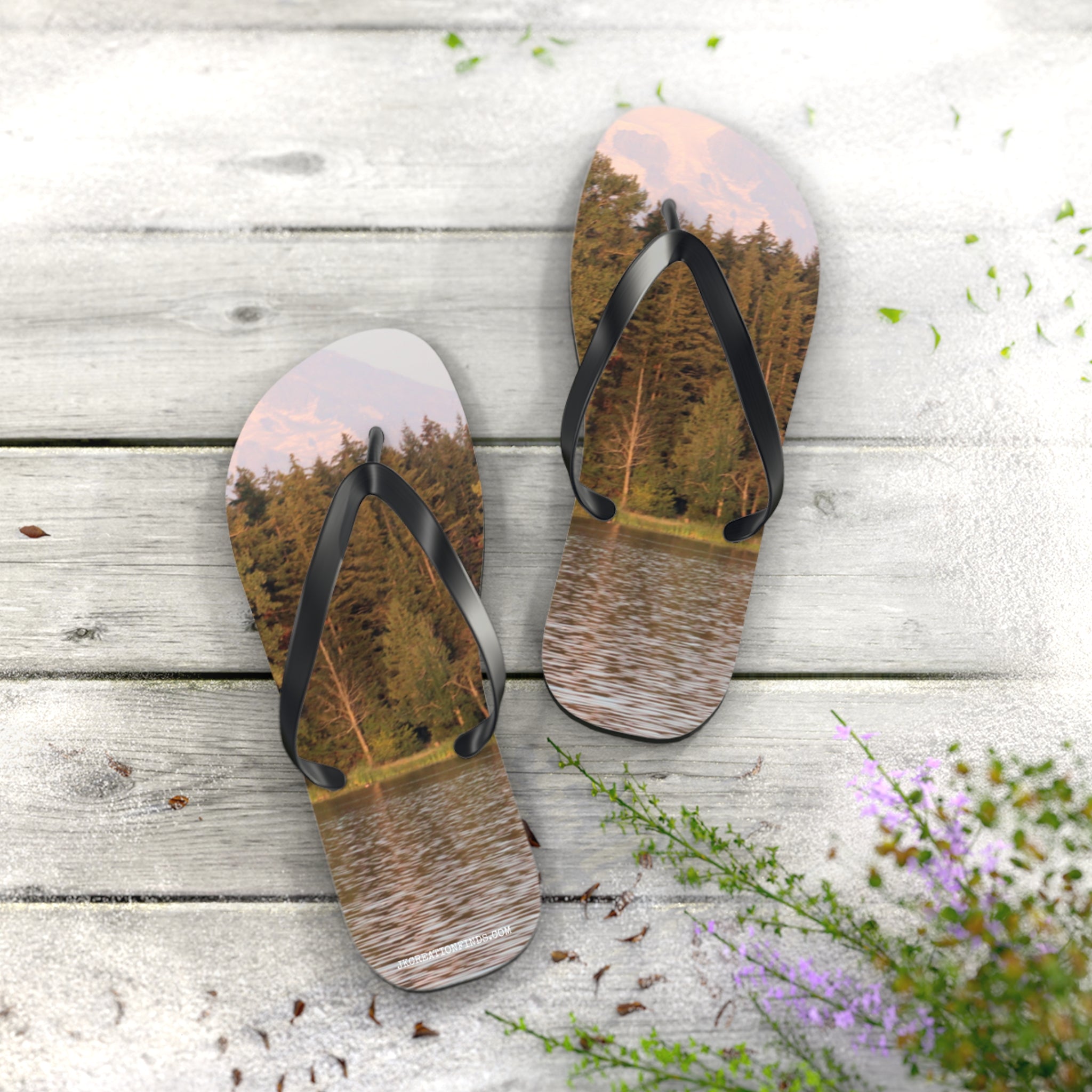 Flip-flops with a forest and lake scene on a wooden deck.