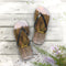 Flip-flops with a forest and lake scene on a wooden deck.