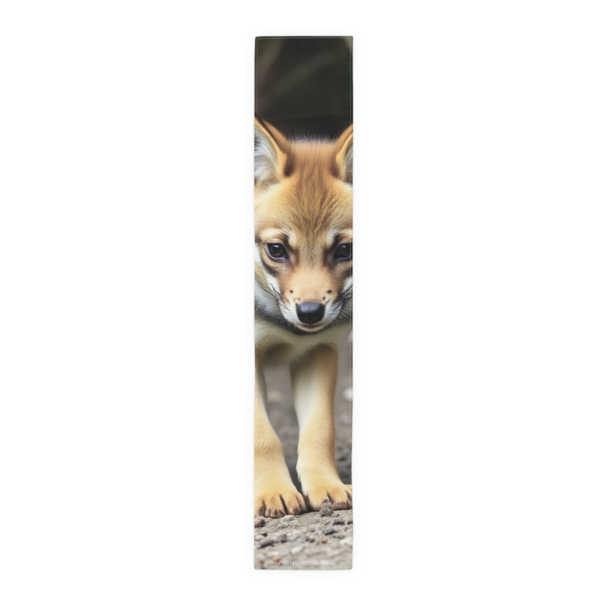 Young fox kit with alert eyes walking towards camera.
