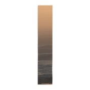 Table runner with abstract ocean sunset waves and a small website address.
