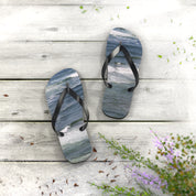 Two flip-flops with ocean wave design on a wooden deck.