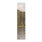 Scenic mountain and forest reflected in calm lake water.