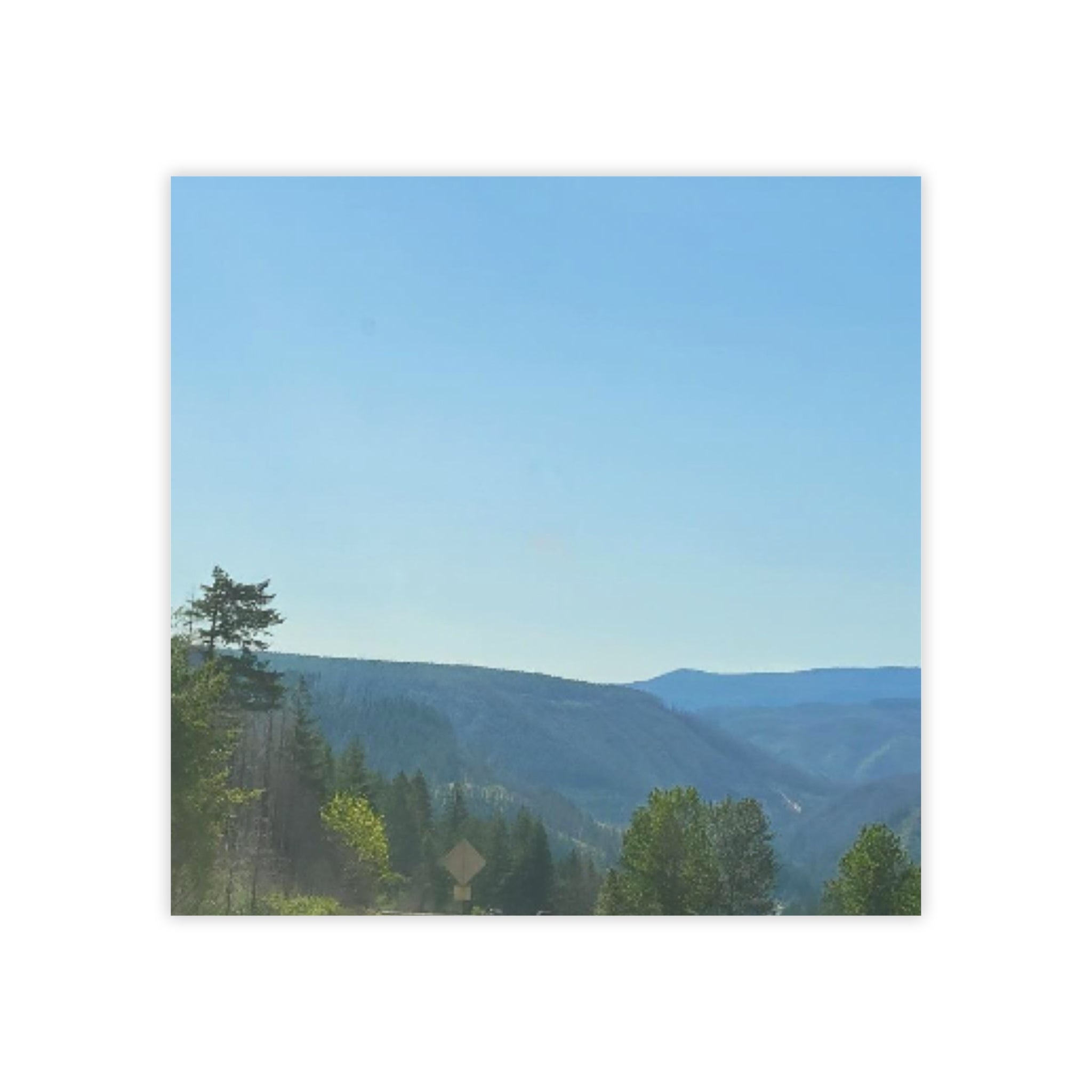 Distant blue mountains and green trees under a clear sky.