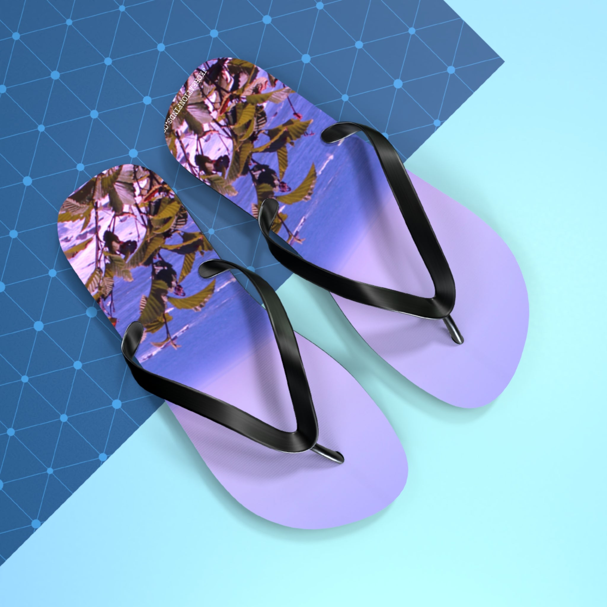 Purple flip-flops with a beach and leafy branch scene on the soles.