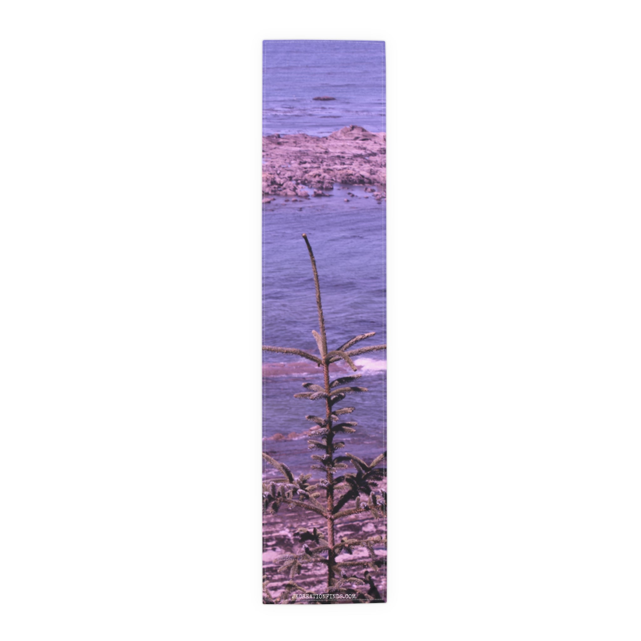 Narrow banner showing a small evergreen tree in foreground and purple ocean.