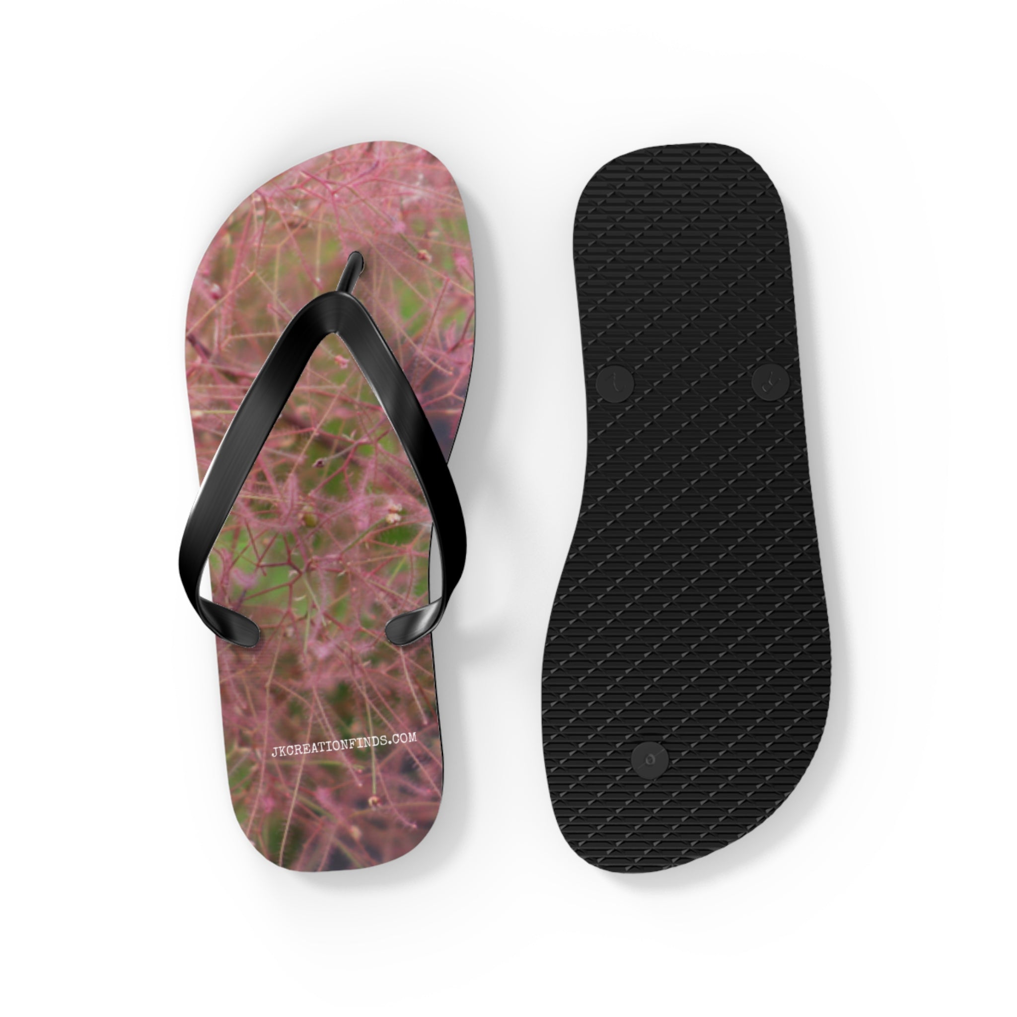 Flip-flops with pink flower pattern and black straps, white background.