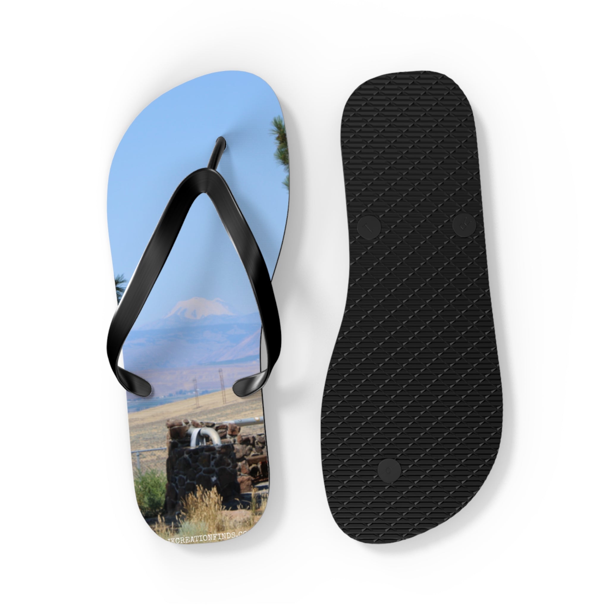 Flip-flops with a landscape scene featuring a fountain and a mountain.