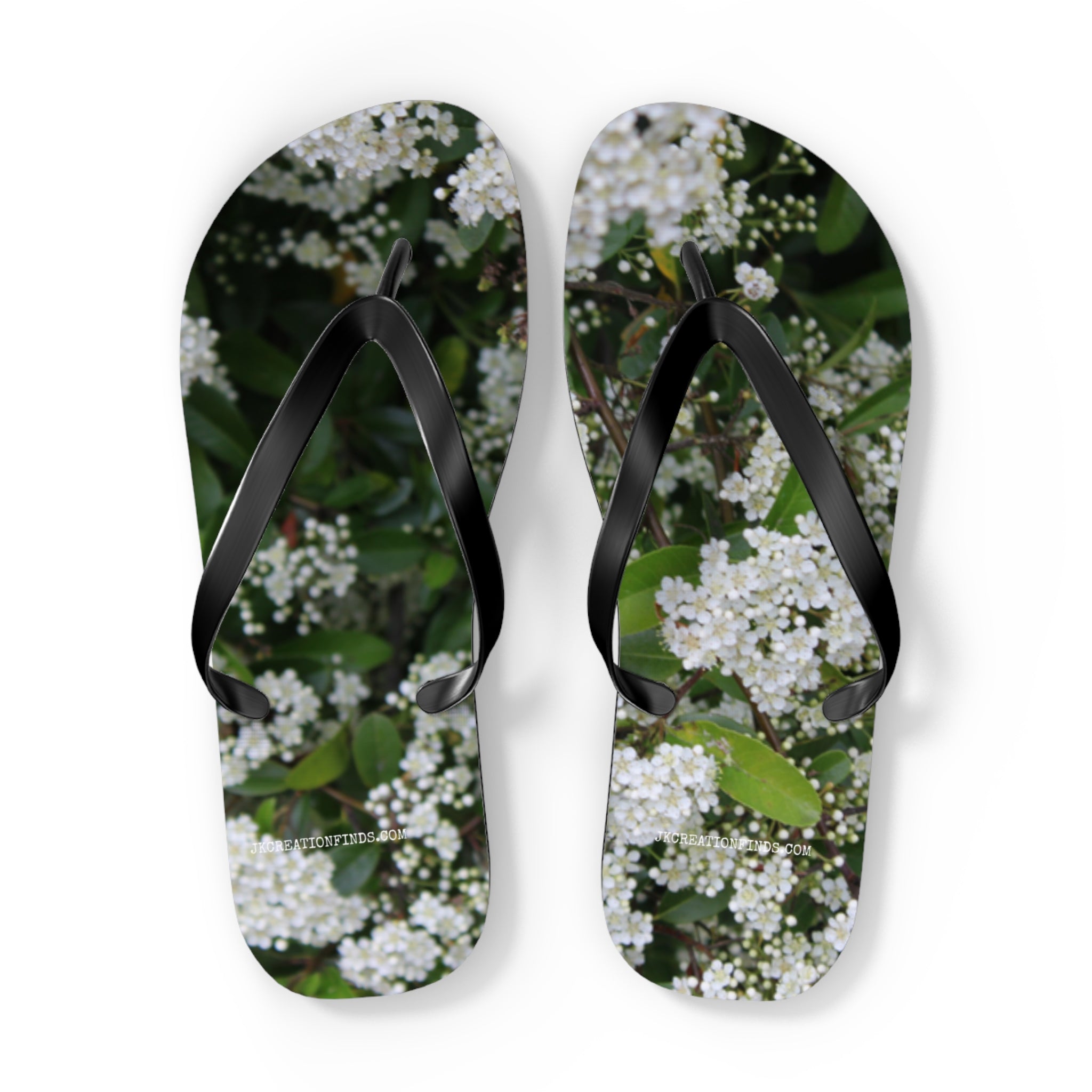 White floral pattern on black flip-flops with white soles.