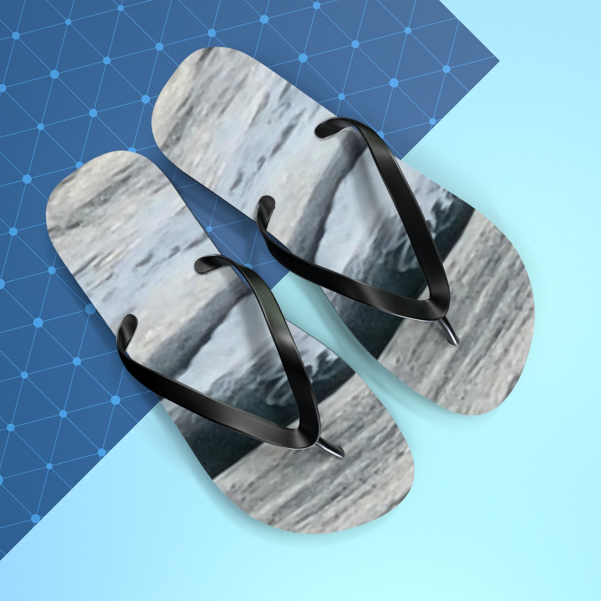 Flip-flops with a textured grey and white sole on a blue and light blue background.