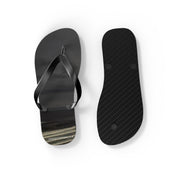 Black flip-flops with abstract patterned soles against a white background.