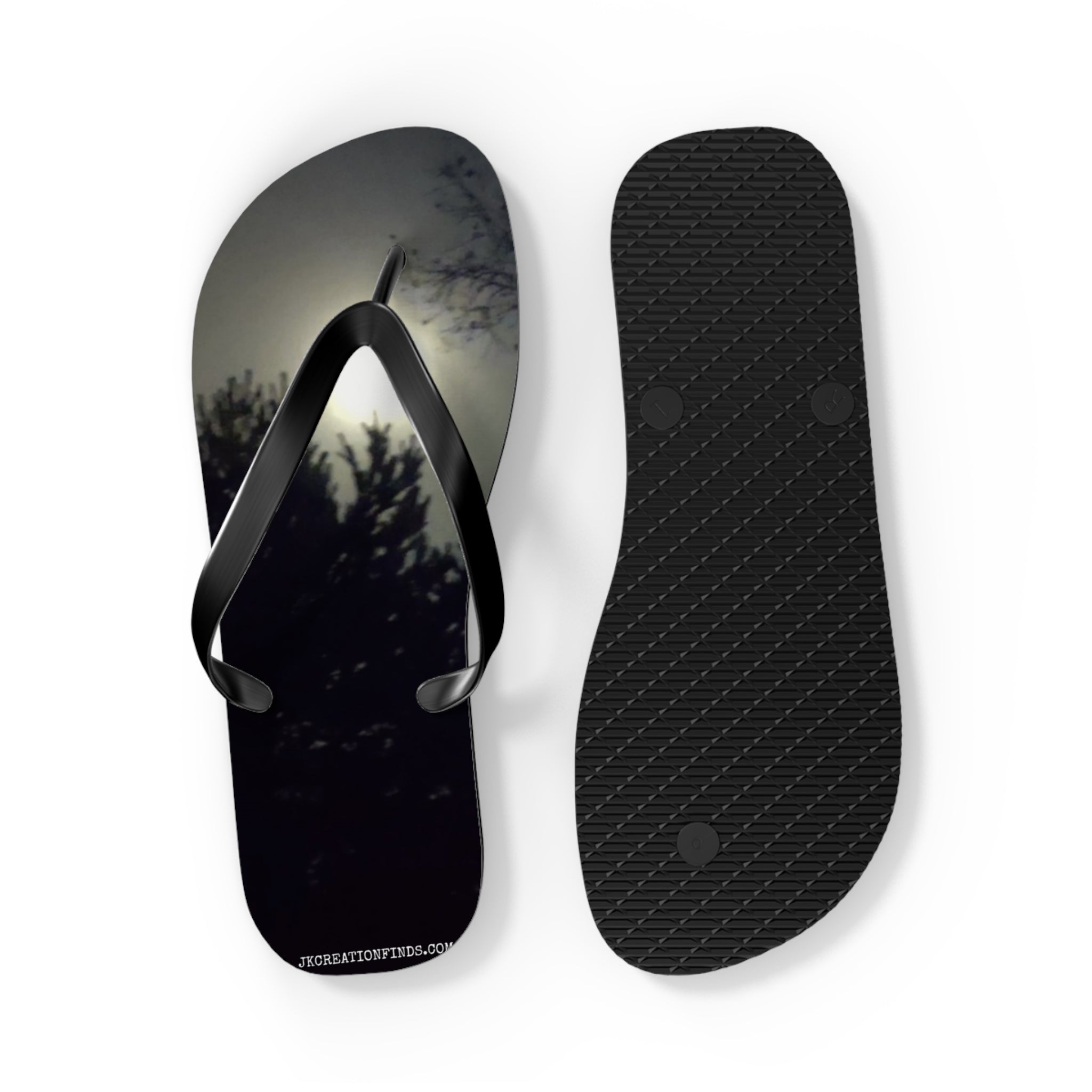 Black flip-flops with a shadowy tree line and moon graphic.