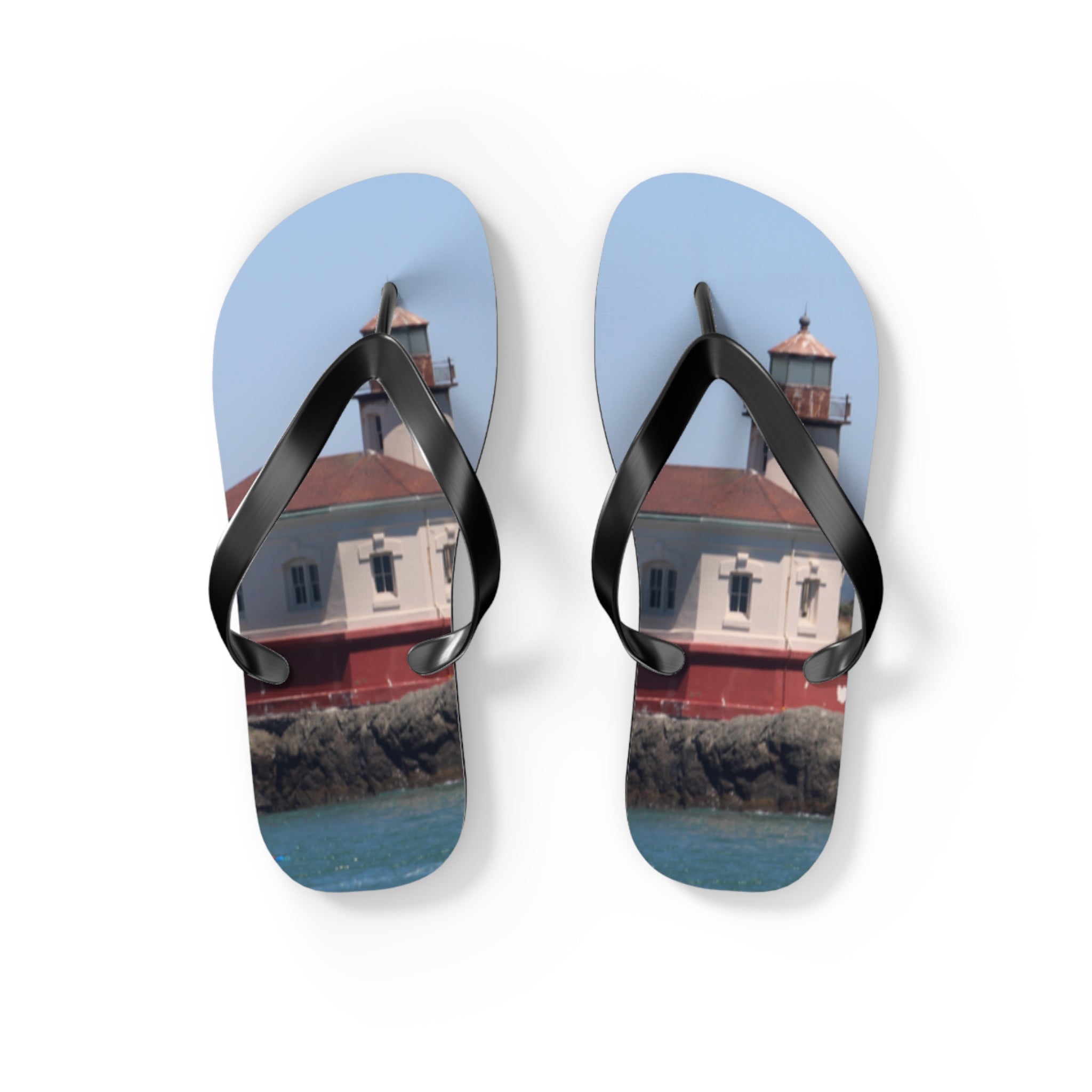 Flip-flops featuring a lighthouse on a rocky coastline.