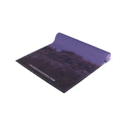 Yoga mat with a purple sky and clouds, featuring website URL.