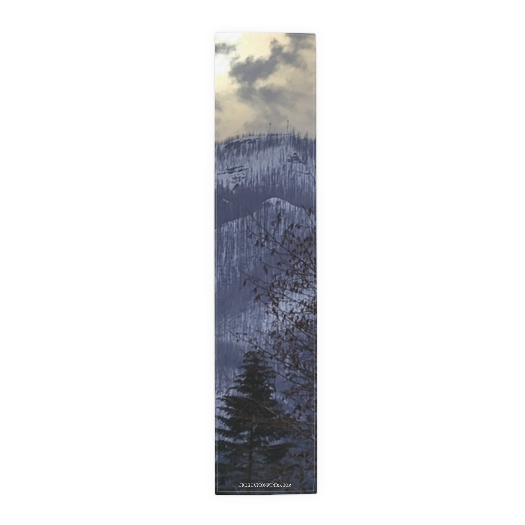Runner with a winter forest and mountain landscape under a cloudy sky.